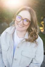 Ashley Kuramoto smiles with a natural and/or garden background