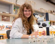 Genevieve van der Voort examines insect samples with a microscope.