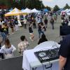 A DJ on a stage plays music while people dance in the background