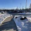 A clear path that has had the snow shoveled off of it with bright blue sky.